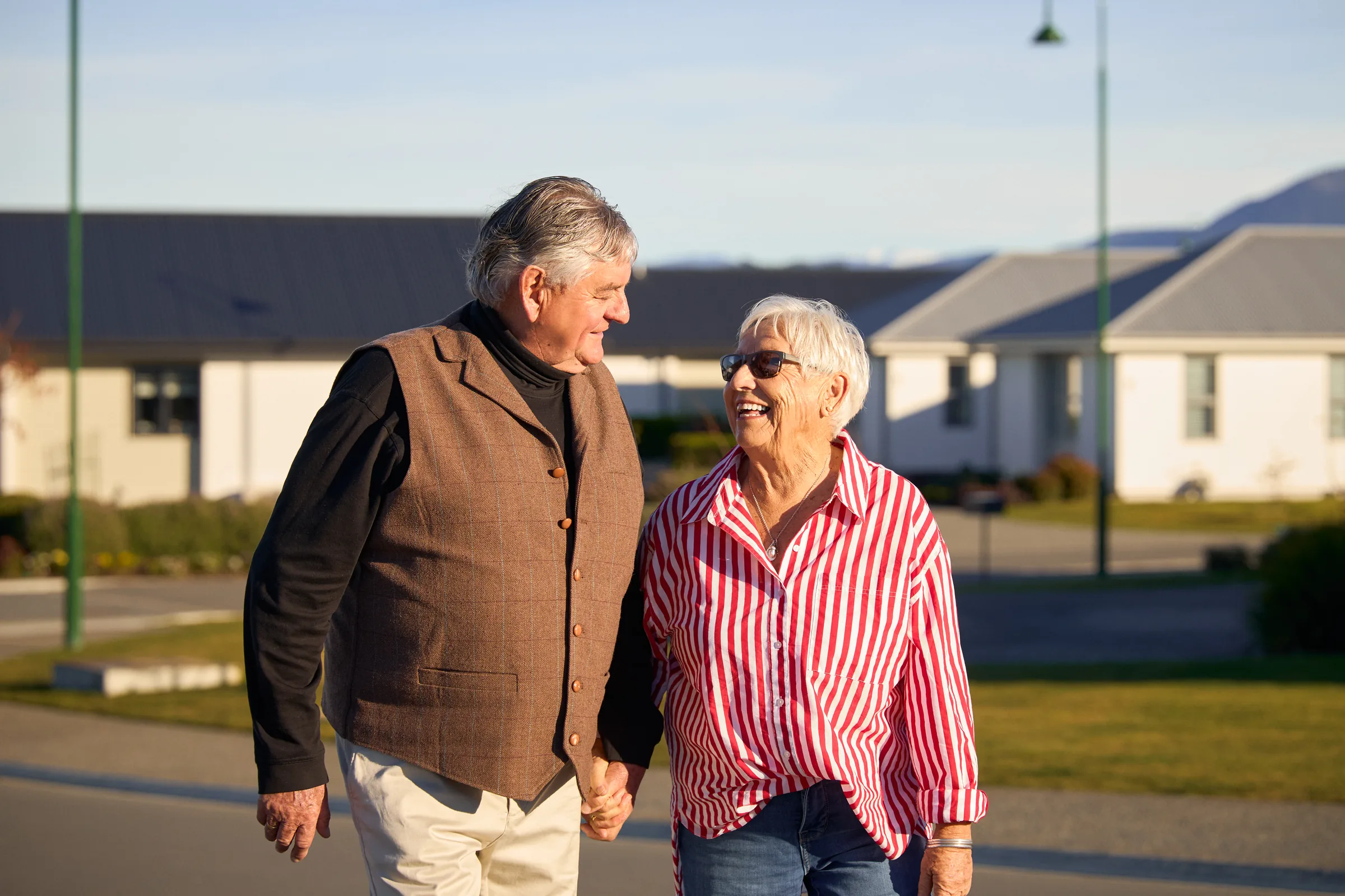 Two residents laughing at each other in low sun.