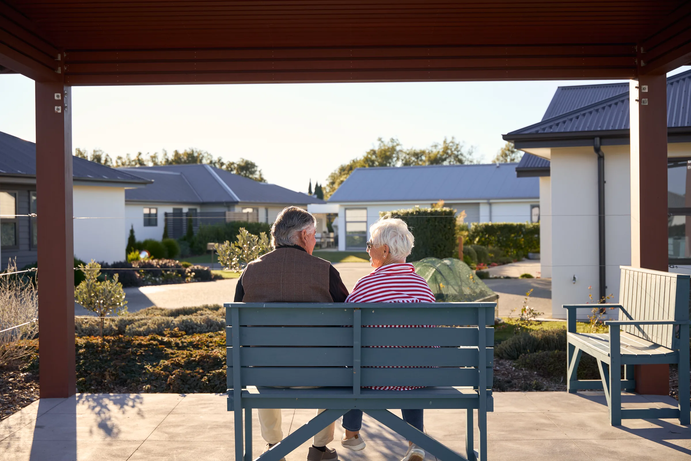 A couple seen from behind, looking across at the homes.