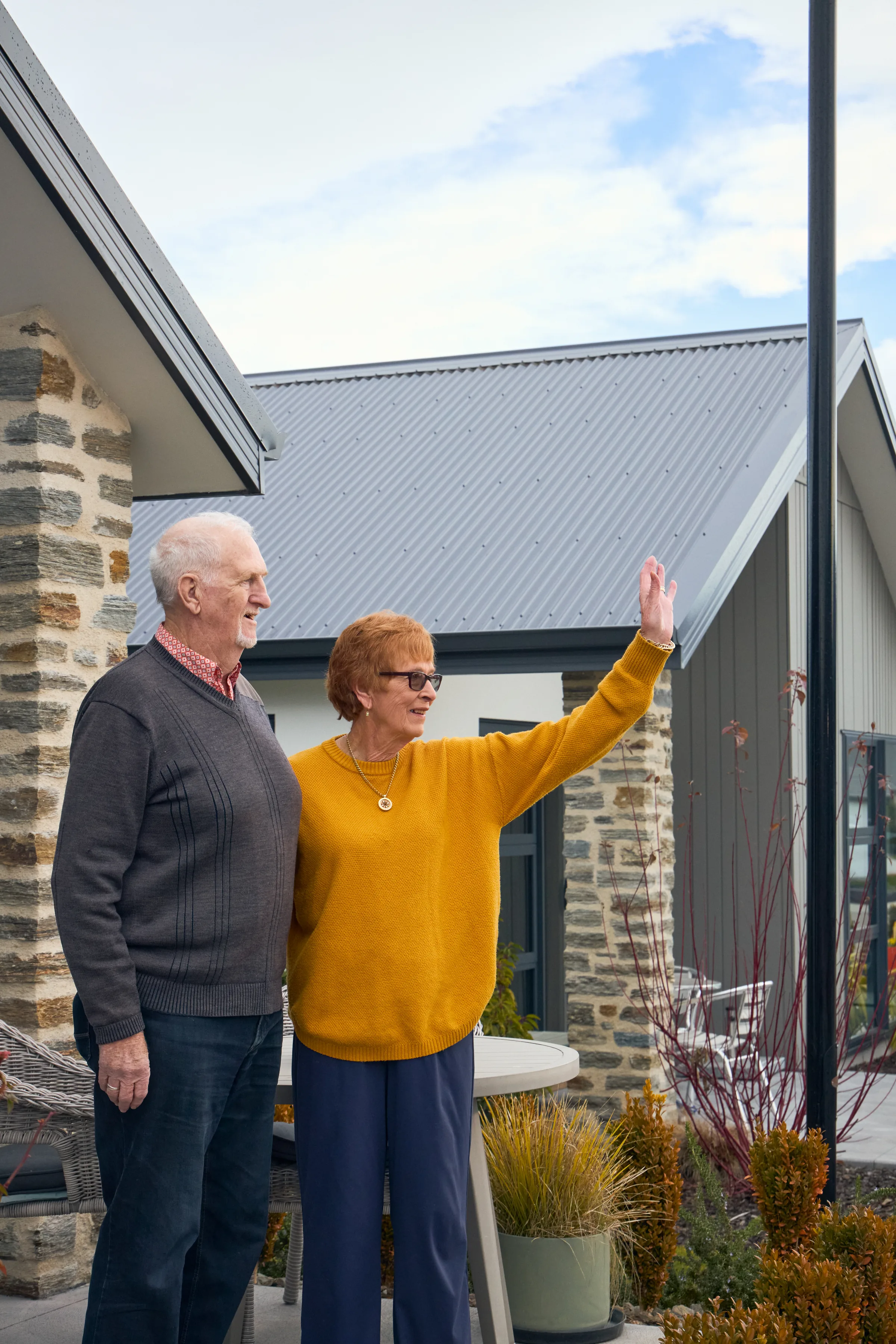 A couple standing together outside their front door.